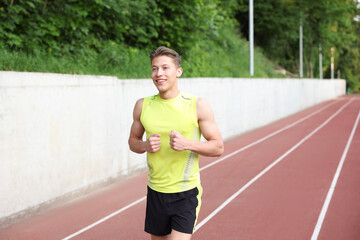 Sporty man running at stadium. Healthy lifestyle