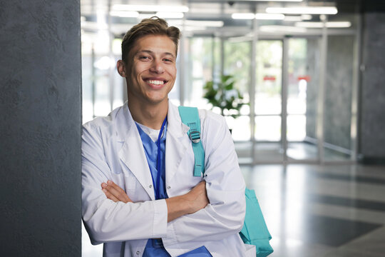 Medical student in uniform with backpack indoors, space for text - Powered by Adobe