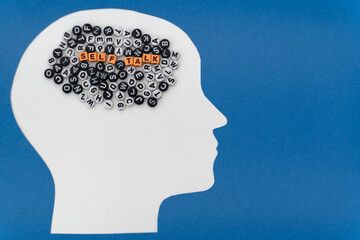 Concept of Self-Talk featuring a paper-cut human head, a vibrant assortment of letters, and the...