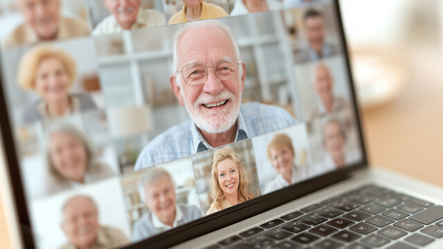laptop screen showing virtual book club meeting with smiling faces, symbol of modern connectivity in retirement