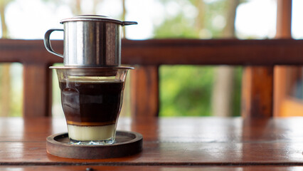 Vienna Coffee or Vietnam Drip with sweet condensed milk on wooden table. Vietnamese traditional drip filter coffee. with copy space
