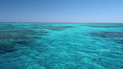 Obraz premium Clear blue sky and turquoise sea in isolated atoll, horizon with no land, crystal clear water, distant islands or coral reefs. Serene minimalist nature beauty.