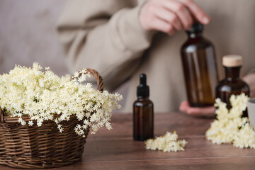 A wicker basket brimming with soft white flowers sits on a wooden surface next to a variety of...