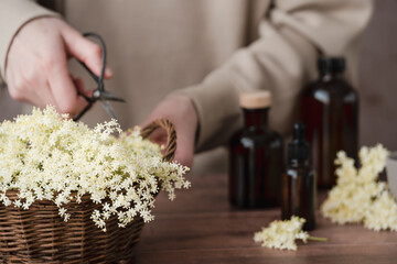 A wicker basket brimming with soft white flowers sits on a wooden surface next to a variety of...