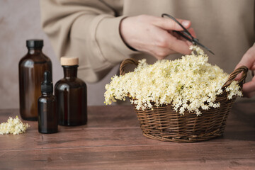 A wicker basket brimming with soft white flowers sits on a wooden surface next to a variety of...
