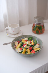 A vibrant salad of fresh ingredients - peaches,spinach, strawberry, cheese drizzled with olive oil, showcasing the essence of healthy eating.