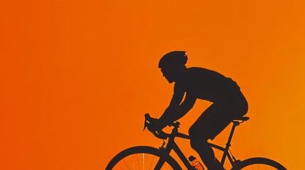Obraz premium The cyclist in silhouette rides confidently through an evening scene bathed in dramatic orange sunset light, showcasing the vibrant colors of a dynamic action shot.