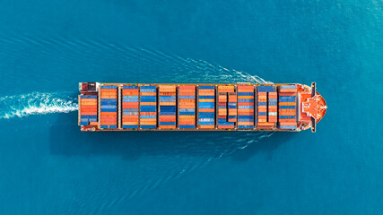 Aerial top view of cargo ships in containers sailing in the sea.