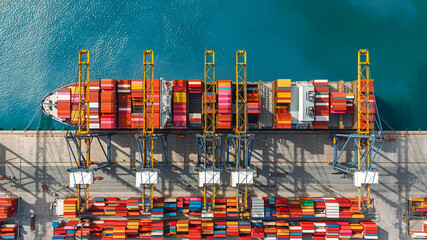 Aerial top view of international port with crane loading containers in import export business...