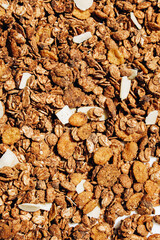 Crunchy granola mix with oats nuts and dried fruits in a bowl for breakfast or snack