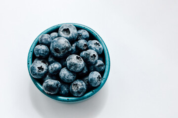 Fresh blueberries in a turquoise bowl ready for a healthy snack or dessert topping