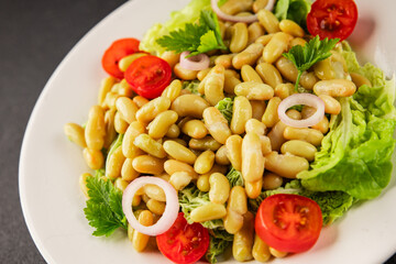 Bean salad green leaf lettuce, tomato, onion vegetables dish fresh delicious gourmet food background on the table rustic food top view copy space keto and paleo diet vegan and vegetarian food