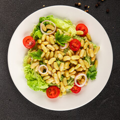 Bean salad green leaf lettuce, tomato, onion vegetables dish fresh delicious gourmet food background on the table rustic food top view copy space keto and paleo diet vegan and vegetarian food