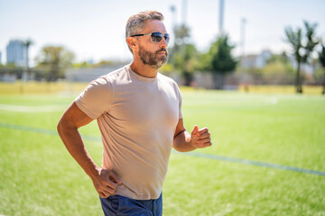 Sport runner in city park. The sportsman running in summer day. Man sportsman running for exercise...