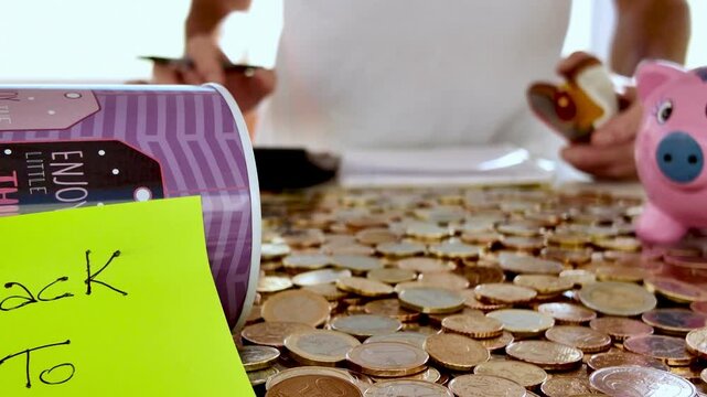 Family financial preparation for educational expenses, carefully counting savings near piggy bank with scattered coins, strategically planning school related costs at home