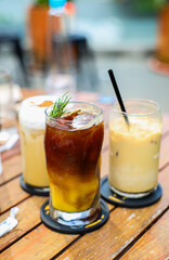 Iced Orange with Espresso Coffee with iced cafe latte in a tall glass on wooden table. Menu for coffee shop