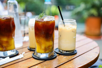 Iced Orange with Espresso Coffee with iced cafe latte in a tall glass on wooden table. Menu for coffee shop