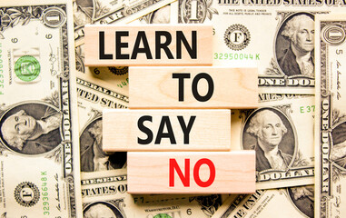 Learn to say no symbol. Concept words phrase Learn to say no on beautiful wooden blocks. Dollar bills. Beautiful dollar bills background. Business psychological Learn to say no concept. Copy space.