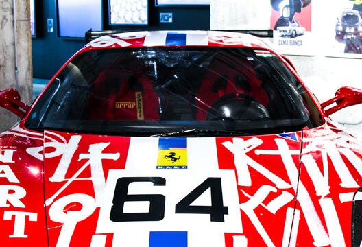 Front view of a Ferrari race car with bold red and white livery, number 64, and prominent sponsor graphics. Miami, FL September 2021