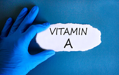 Vitamin A symbol. Concept words Vitamin A on beautiful white paper. Doctor's hand in blue medical...