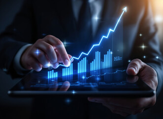 Businessman hand interacts with futuristic digital graph on tablet, showcasing glowing upward trend. image conveys innovation and success in business analytics