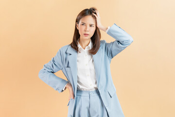 Unhealthy Asian businesswoman touching body and have a headache on beige color background.