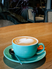 Steaming cup of coffee on a wooden table in a cozy cafe setting