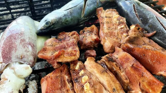 grilled fish and cuttlefish and rib meat on the grill over coals