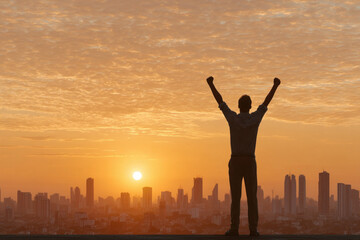 Silhouette man city sunrise success achievement arms raised sky urban motivation happiness emotional morning skyline inspiration hope freedom