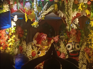 A colorful and detailed display of a Hindu deity, Adorned with elaborate floral decorations.