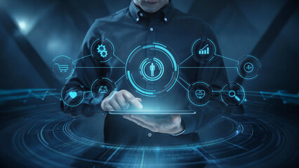 Man using a tablet to interact with a glowing futuristic digital interface displaying various icons and data visualizations