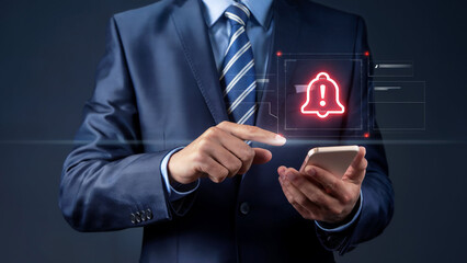 Businessman interacting with a glowing red notification bell icon on a futuristic digital interface displayed on his smartphone