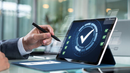 Businessman using a stylus on a tablet displaying a digital interface with a large checkmark and multiple completed tasks