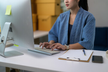 Young Asian woman entrepreneur working on computer in home office, online business, work from home concept