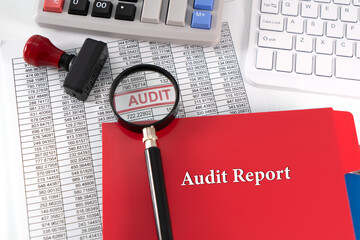 A photo concept for Audit Report;  A detailed report is placed under a magnifying glass,...