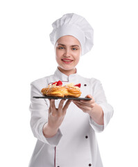 Happy confectioner in uniform holding delicious profiteroles with strawberries on white background