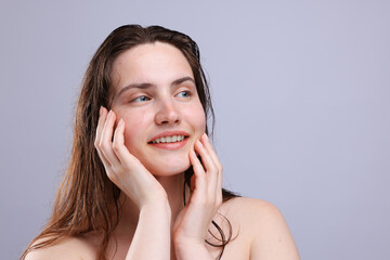 Smiling woman with natural skin complexion on grey background, closeup. Space for text