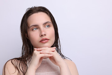 Beautiful woman with natural skin complexion on light grey background, closeup. Space for text