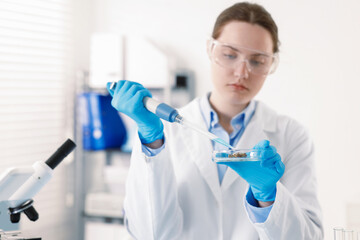 Scientist working with sample in Petri dish in laboratory, selective focus