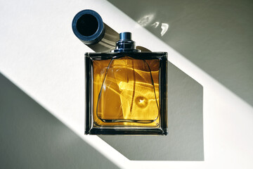 A golden bottle of perfume in a sunbeam.