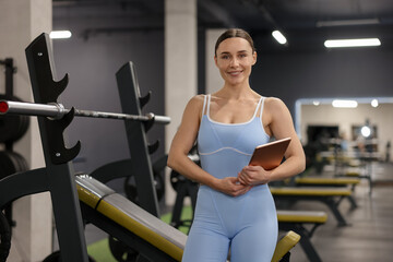 Professional personal trainer with tablet in gym