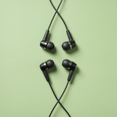 Black wired earphones on a green background for music listening