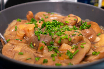 Bowl of food with mushrooms and parsley on top. The dish looks delicious and inviting. The parsley adds a pop of color and freshness to the dish, while the mushrooms provide a savory.