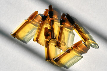 Ampoules on a gray background with stripes of shadows.
