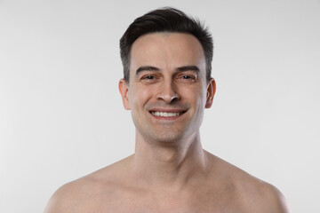 Naklejka premium Portrait of smiling man on light grey background, closeup