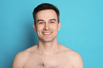 Smiling man after shaving on light blue background