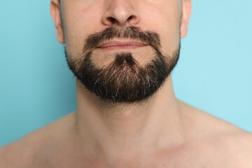 Man before shaving on light blue background, closeup