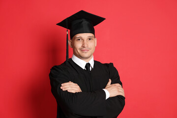 Portrait of student after graduation on red background