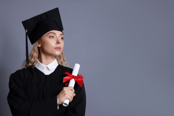 Student with diploma after graduation on grey background. Space for text