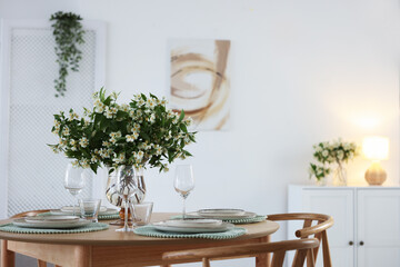 Bouquet of beautiful jasmine flowers on dining table indoors. Space for text
